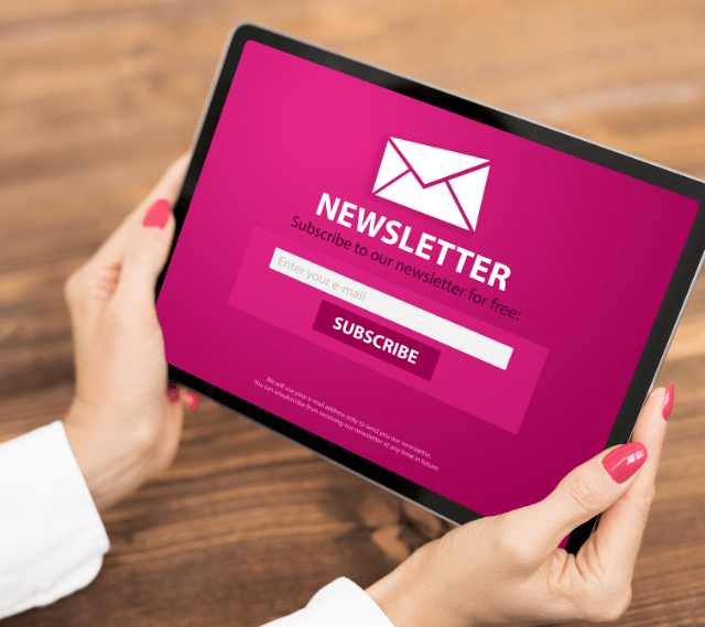 woman holding a tablet with a newsletter optin screen showing